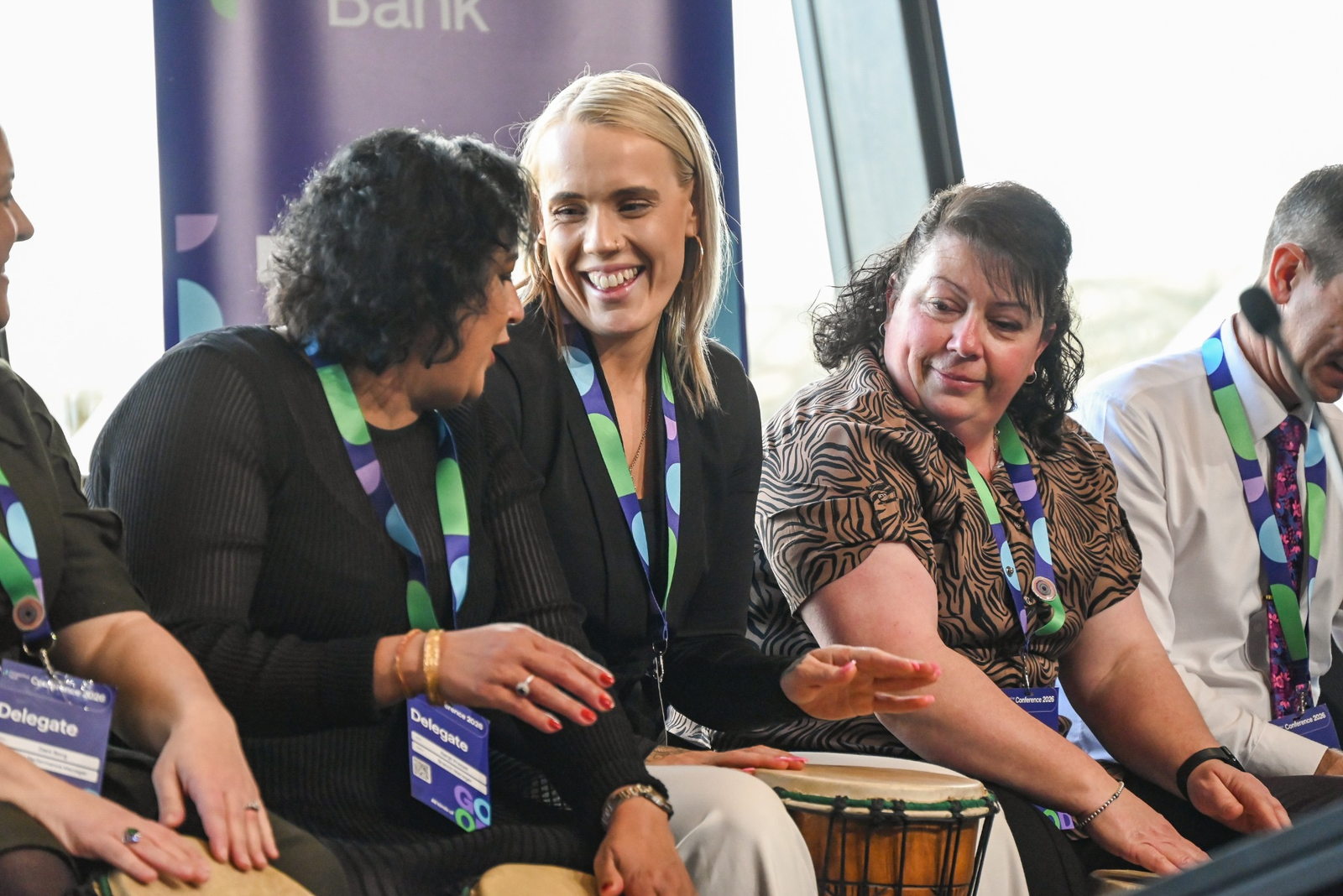 Conference delegates smiling and interacting during an InRhythm drumming session